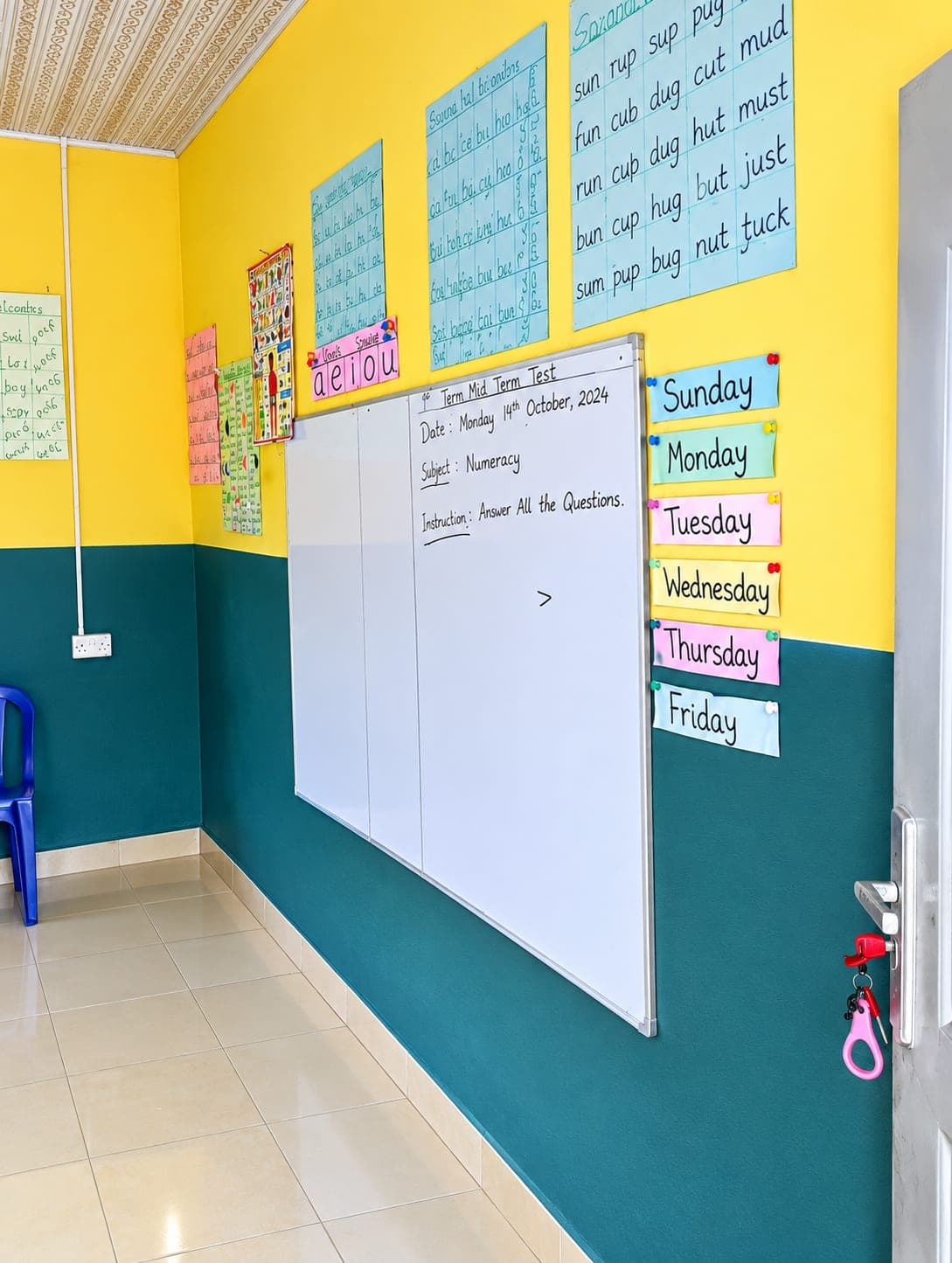 A bright EFGC classroom with phonics charts, days-of-the-week labels and a whiteboard